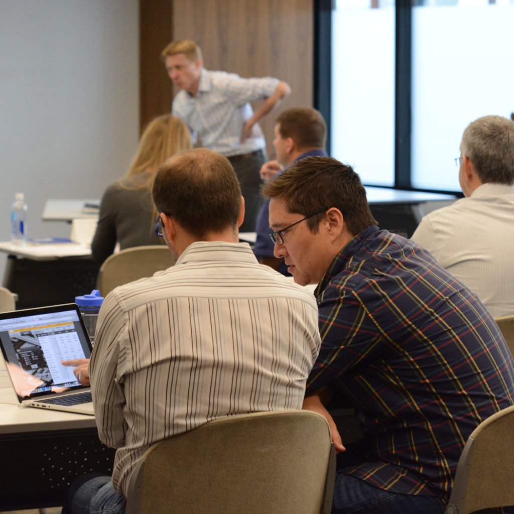 Employees working together on a business simulation during the Creating Strategic Business Value program 